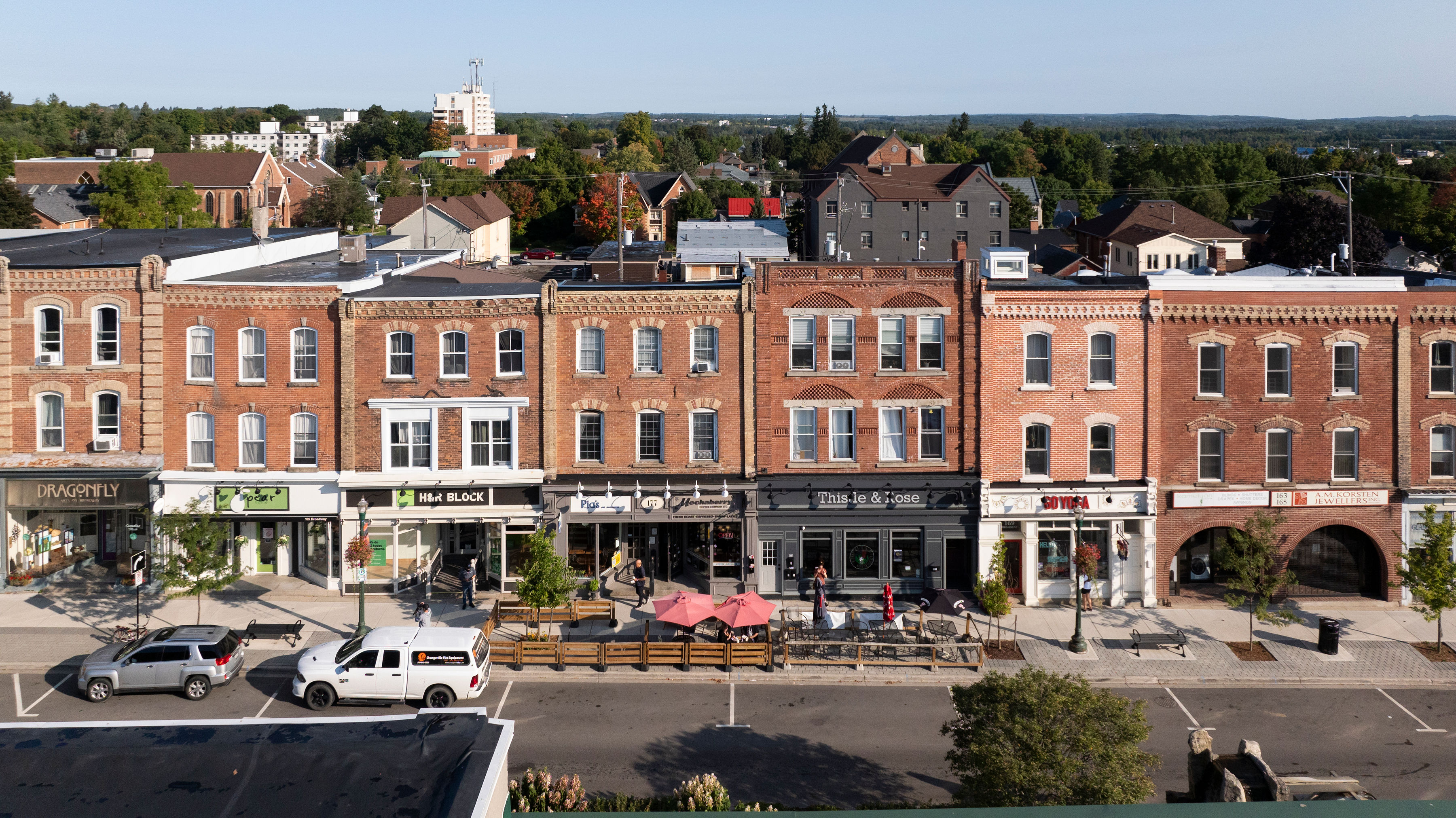 Dufferin County downtown street with cars next to historic brick buildings housing modern shops