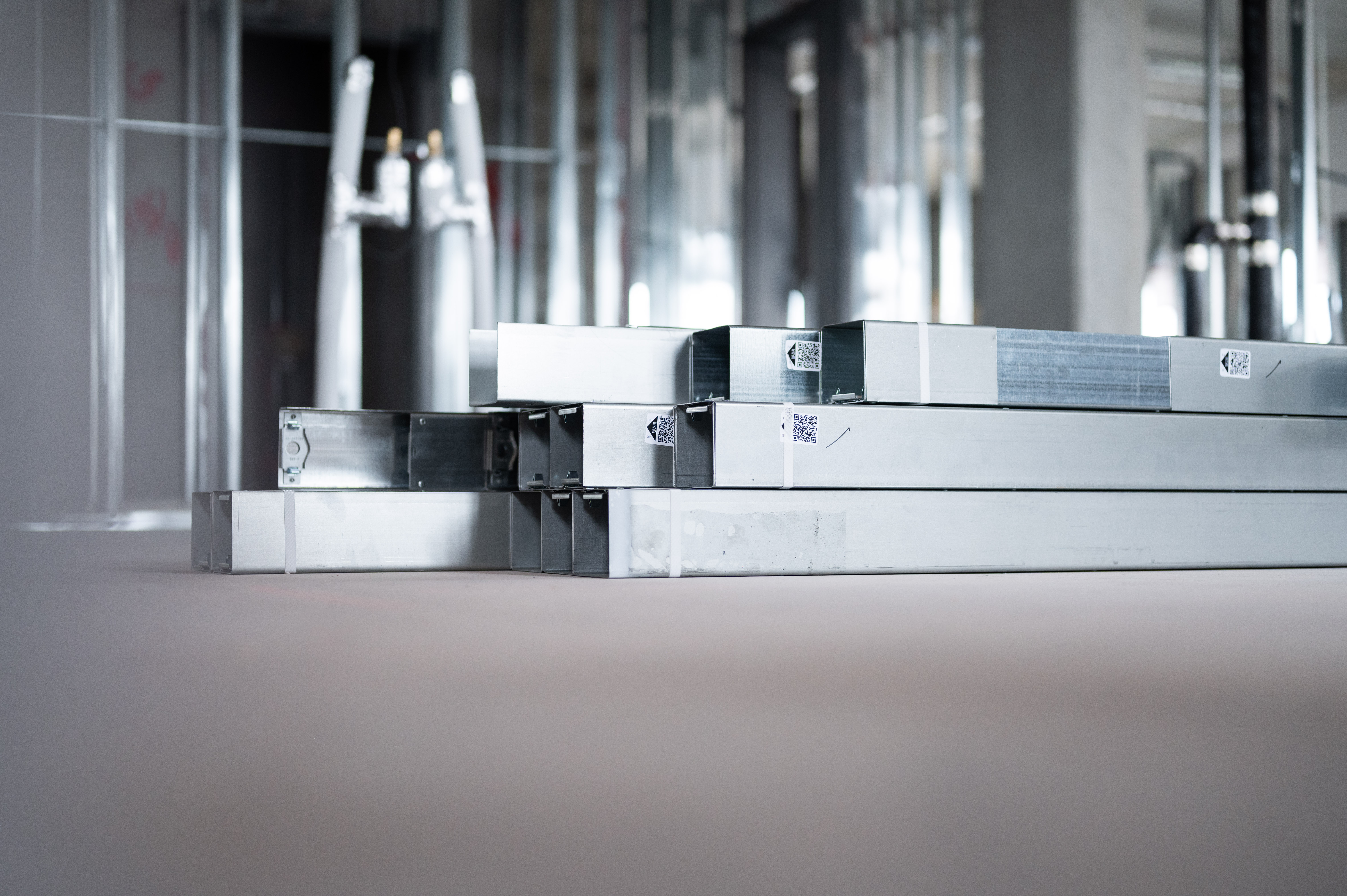 Stacks of metal construction materials in an unfinished corporate building interior