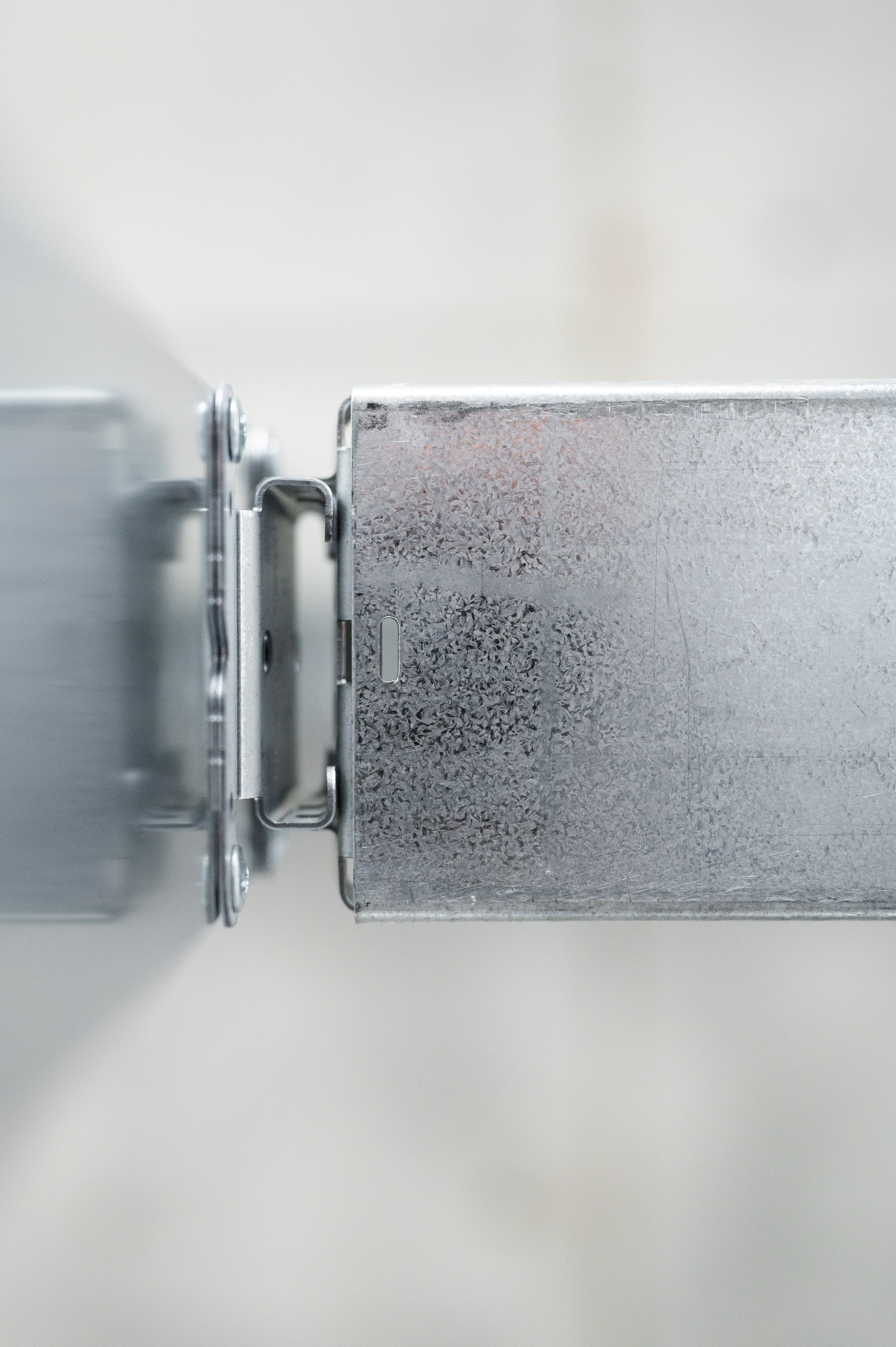 Close-up of industrial galvanized metal components connected by a structural bracket