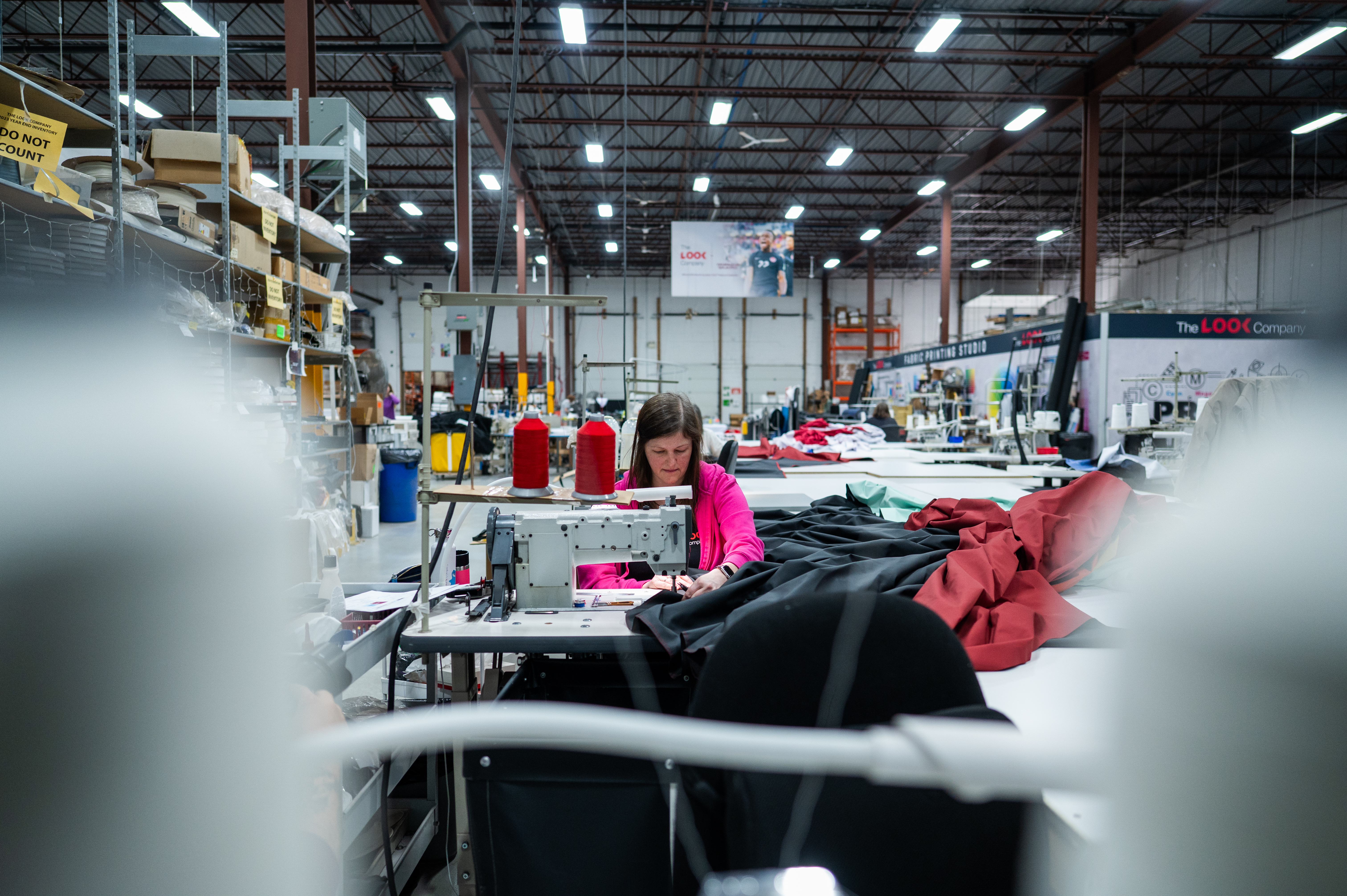 Seamstress sewing custom fabric for large-scale event branding inside The Look Company factory
