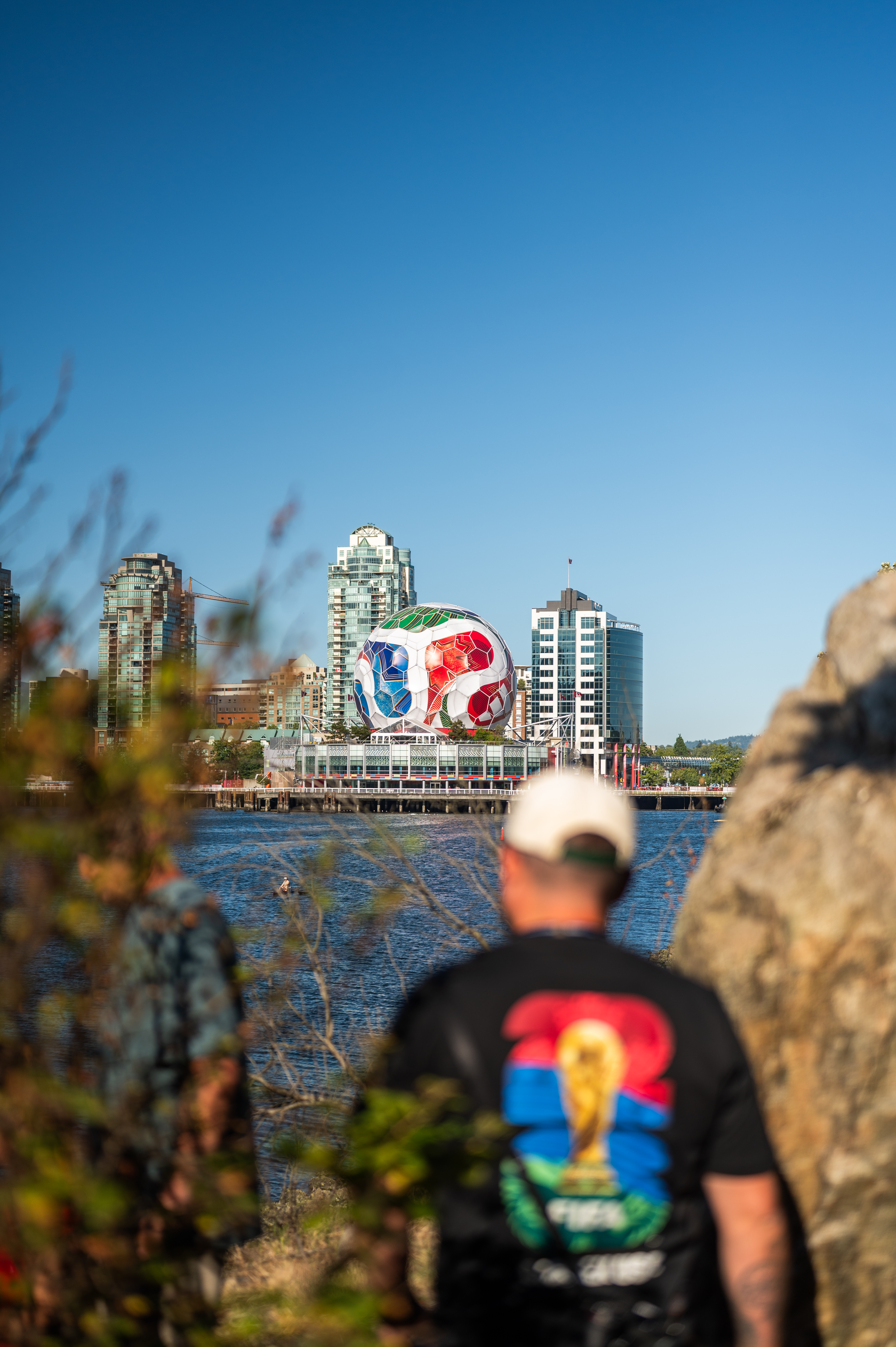 Man views a massive FIFA World Cup soccer ball in a city skyline