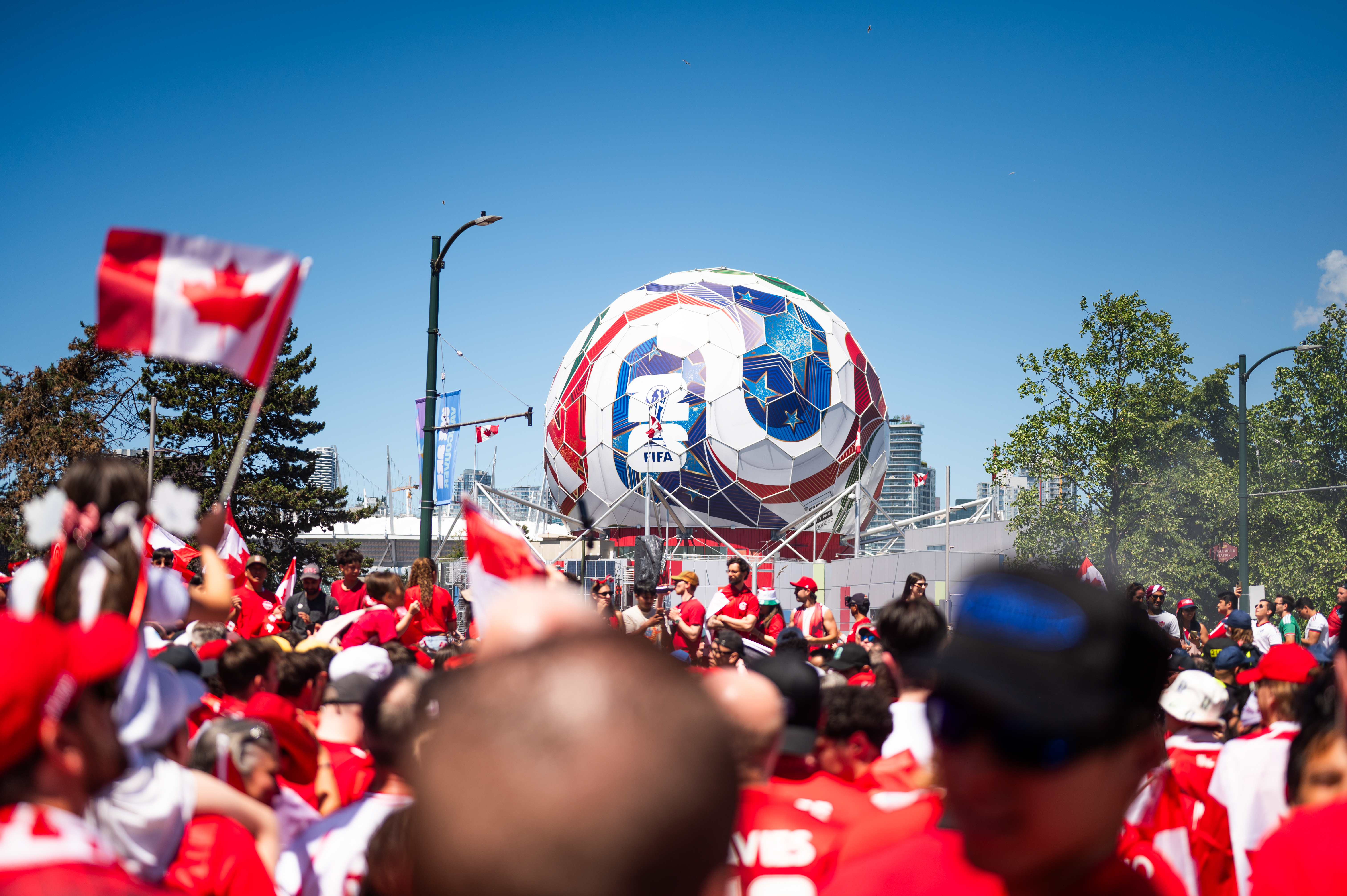 World Cup fans and a large FIFA soccer ball installation in a vibrant city