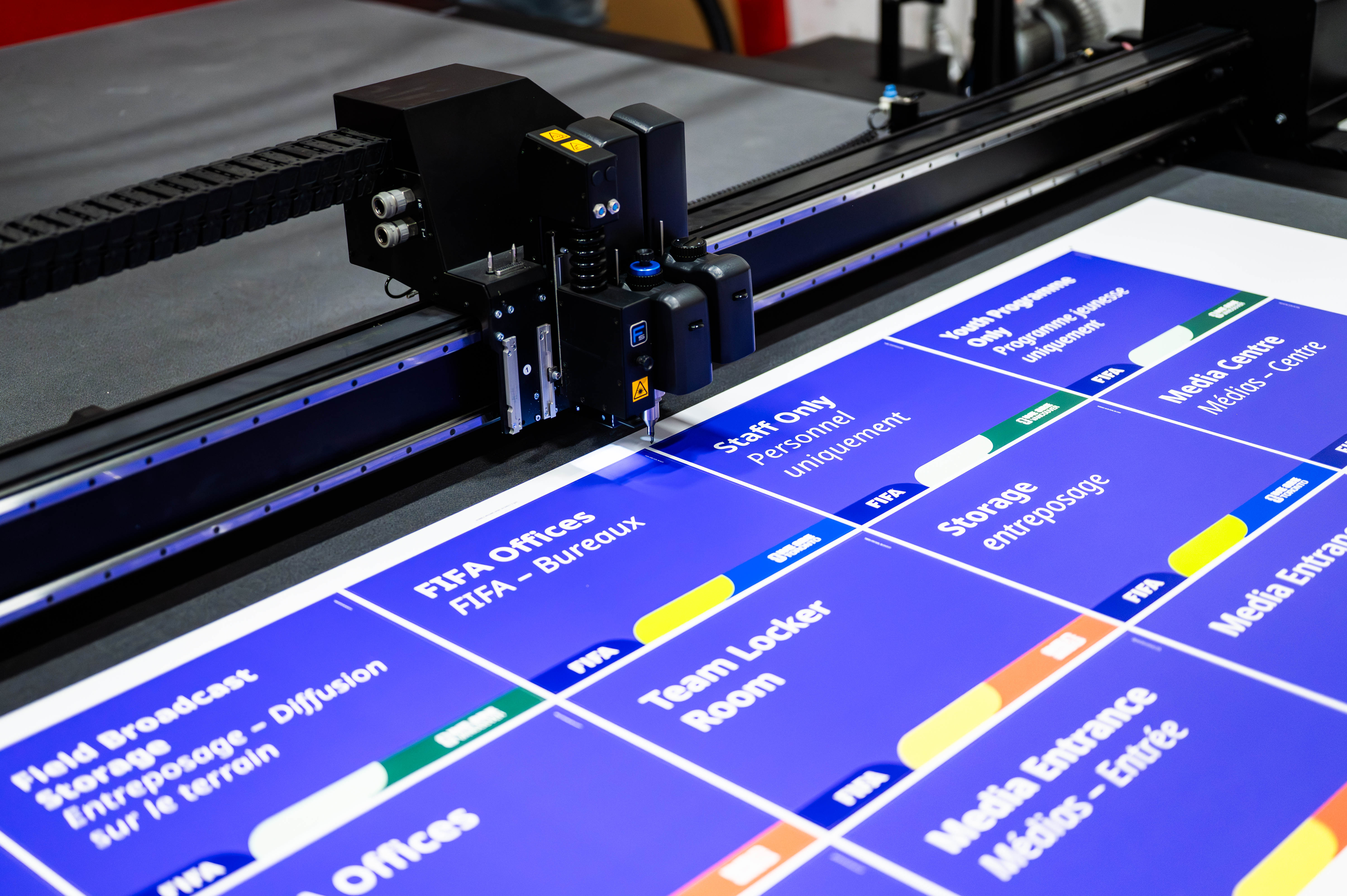 Cutting machine preparing large blue signage for FIFA World Cup event branding