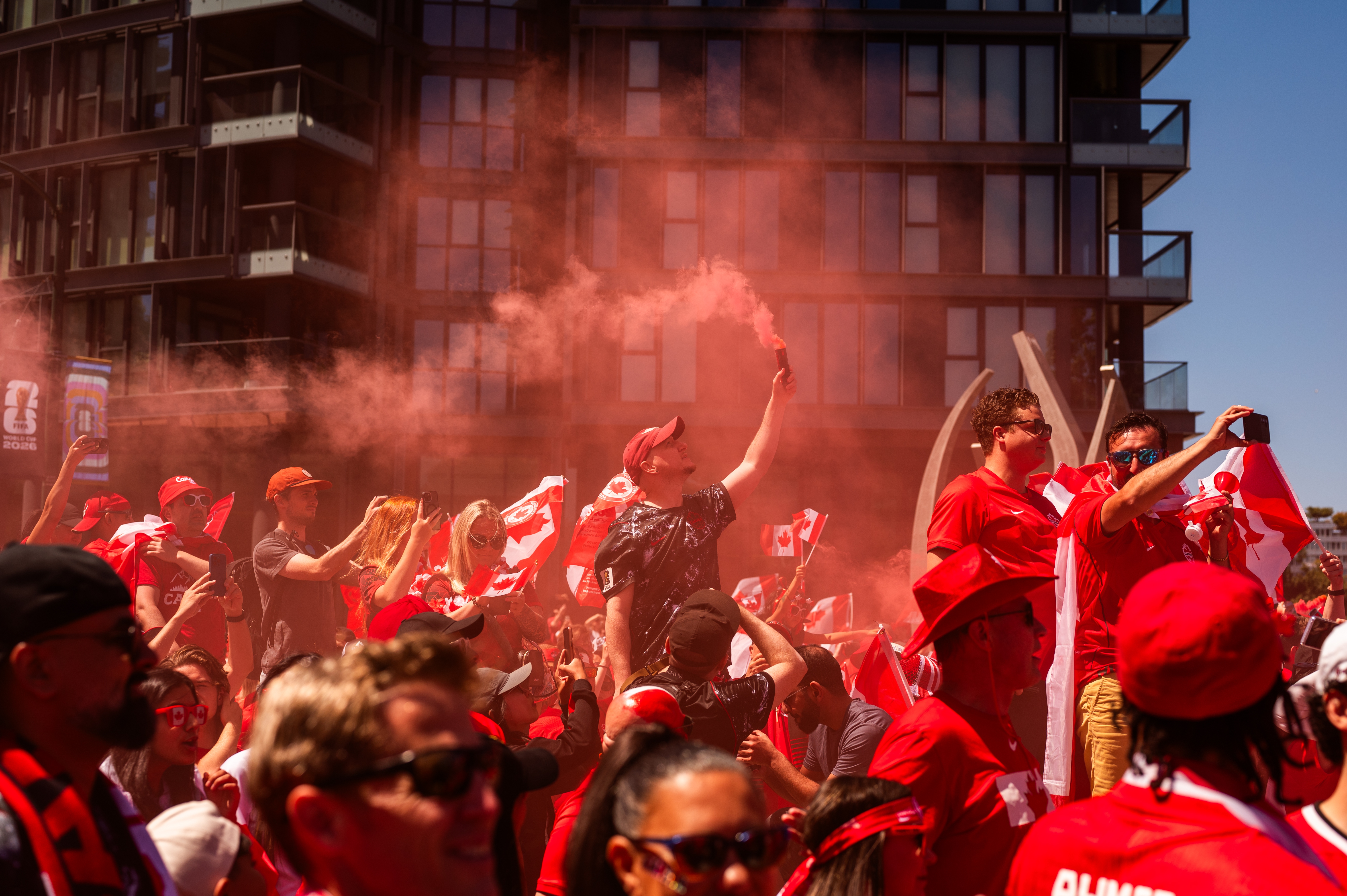 World Cup fans celebrating in a city street, waving flags and red smoke